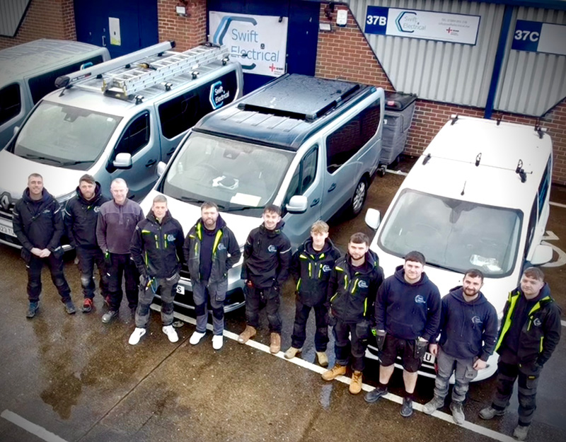 Group Photo of Swift Electrical Newcastle Team Next to Vans
